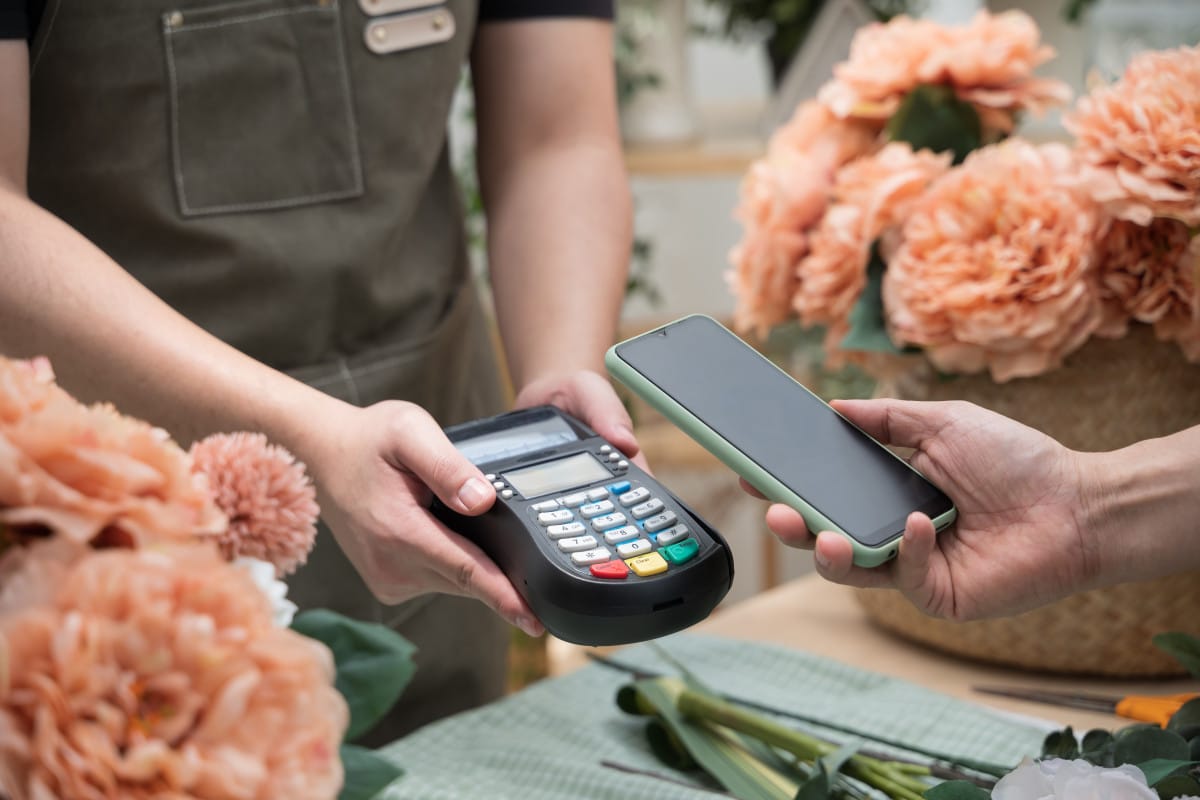 customer using phone for payment in flower shop n 2022 07 22 17 57 22 utc